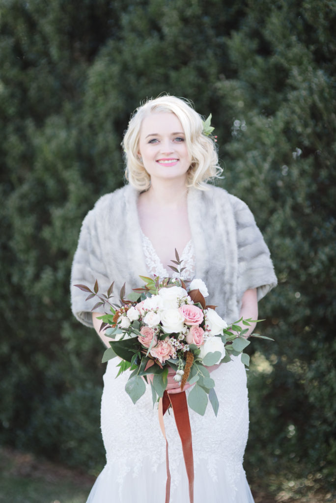 Bridal Portraits taken on a cold January Day and the bride is wearing a fur wrap and is smiling at the camera