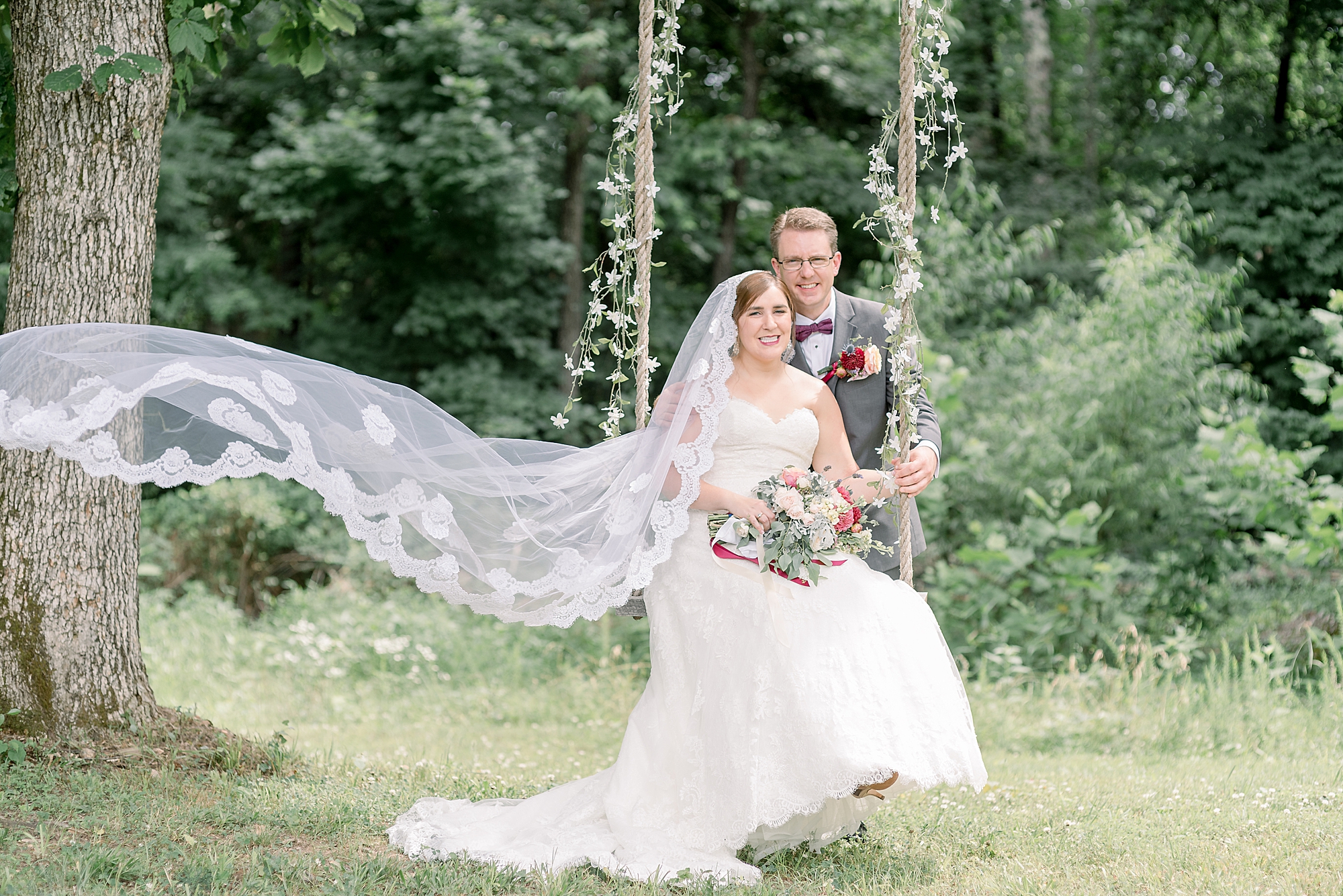 bride and groom are sitting on a floral swing after sharing a first look before their wedding ceremony
