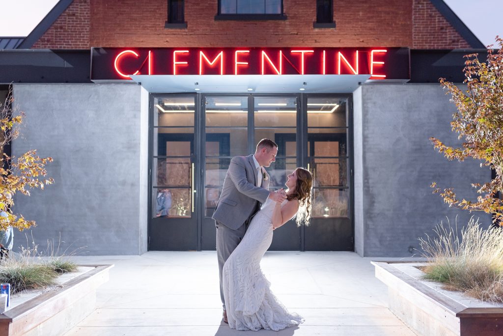 Husband is dipping his new wife in front of the Clementine Wedding Venue in Nashville TN at night