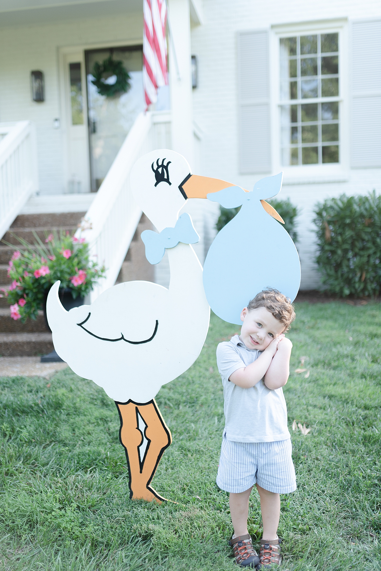 Older brother is standing in front of a stork which is in the front yard of his house in Brentwood TN