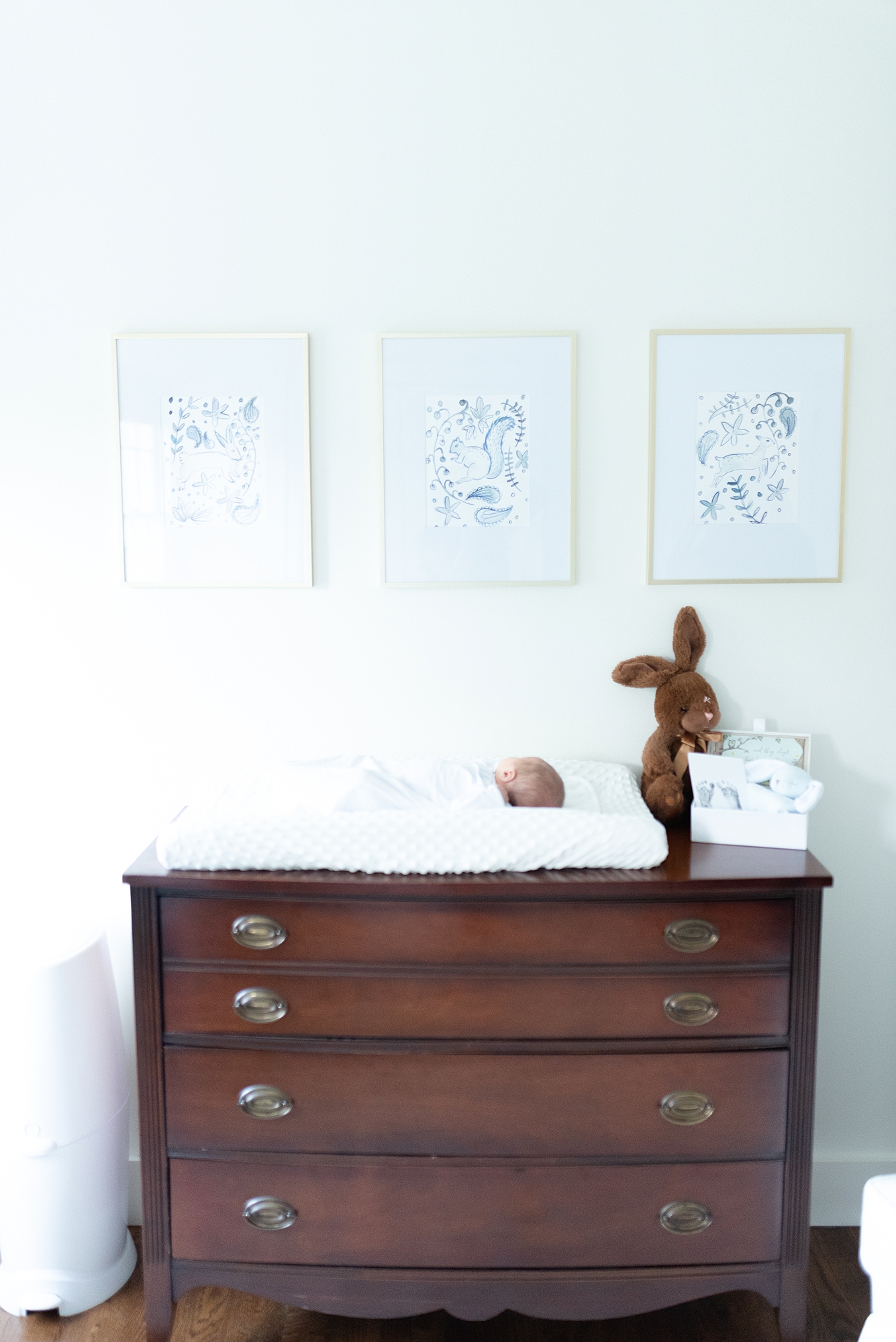 Newborn son laying on his pottery barn themed nursery changing table