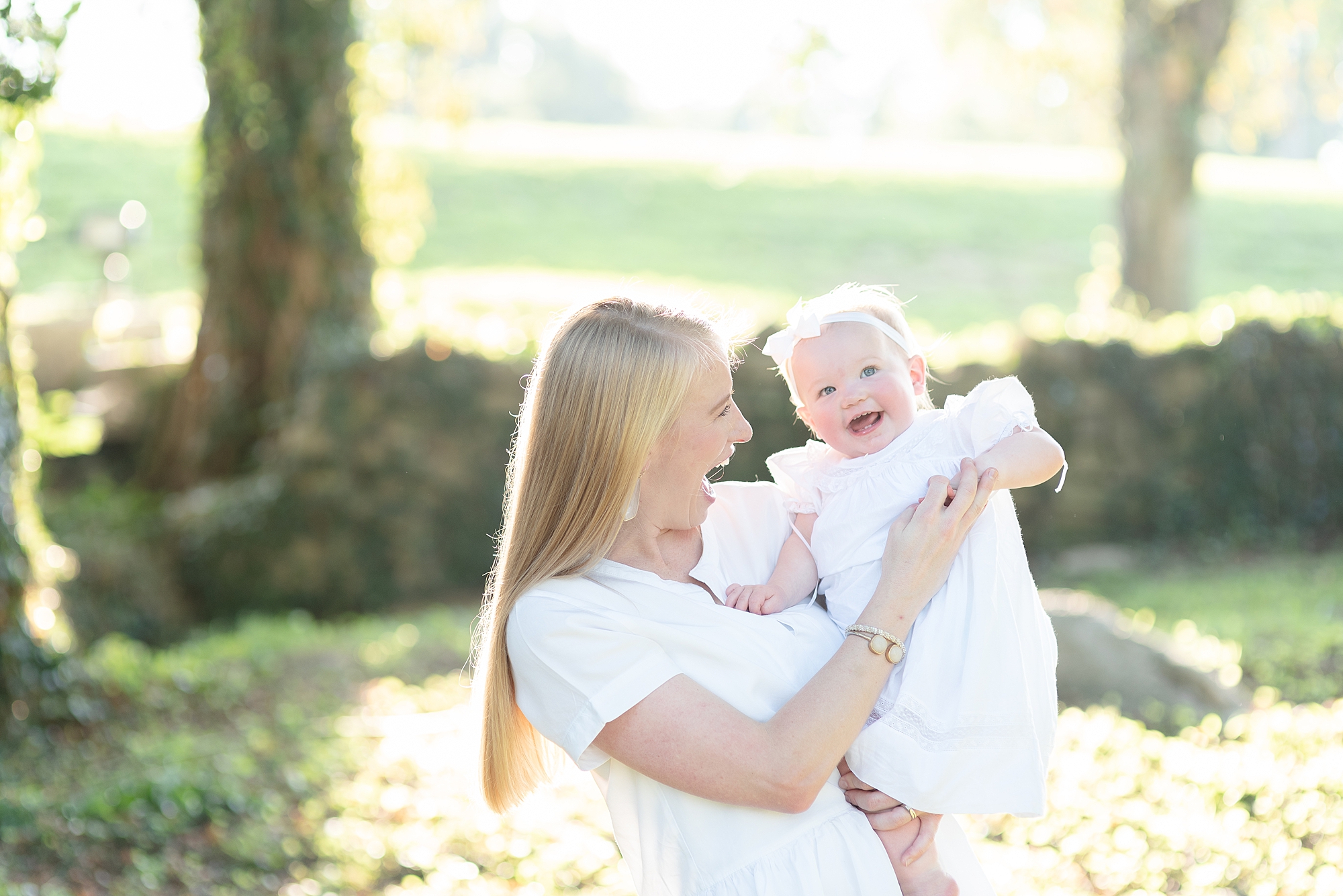 Mom is tickling her baby girl for her one year portraits at Ravenswood mansion in Nashville
