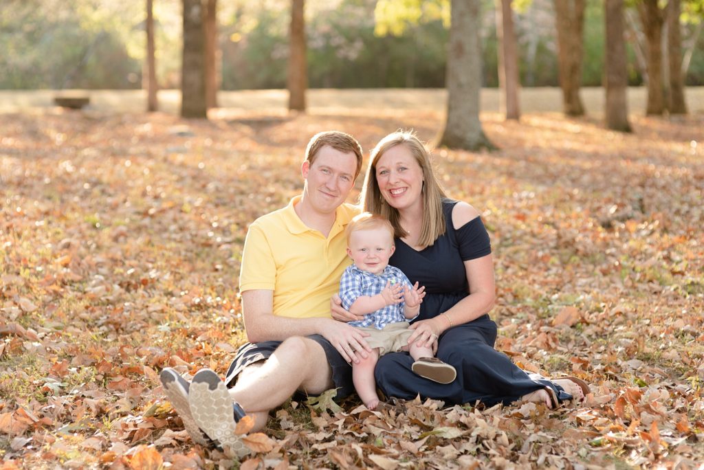 Family of Three Sitting in Fall Leaves in Nashville for family portraits by Dolly DeLong Photography Nashville and Montana Family Photographer