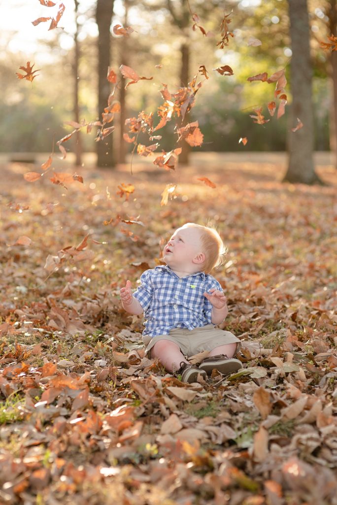 One year old boy sitting in leaves for portraits in Nashville by Dolly DeLong Photography Nashville and Montana Family Photograper
