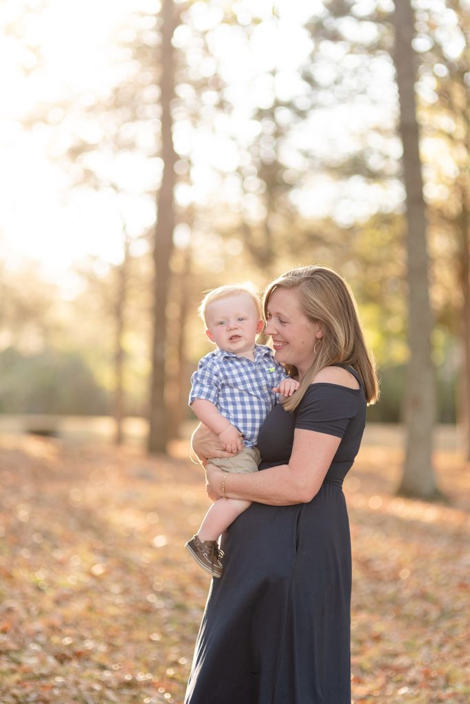 New Mom is snuggling her baby boy for family portraits in the woods in Nashville by Family Photographer Dolly DeLong Photography
