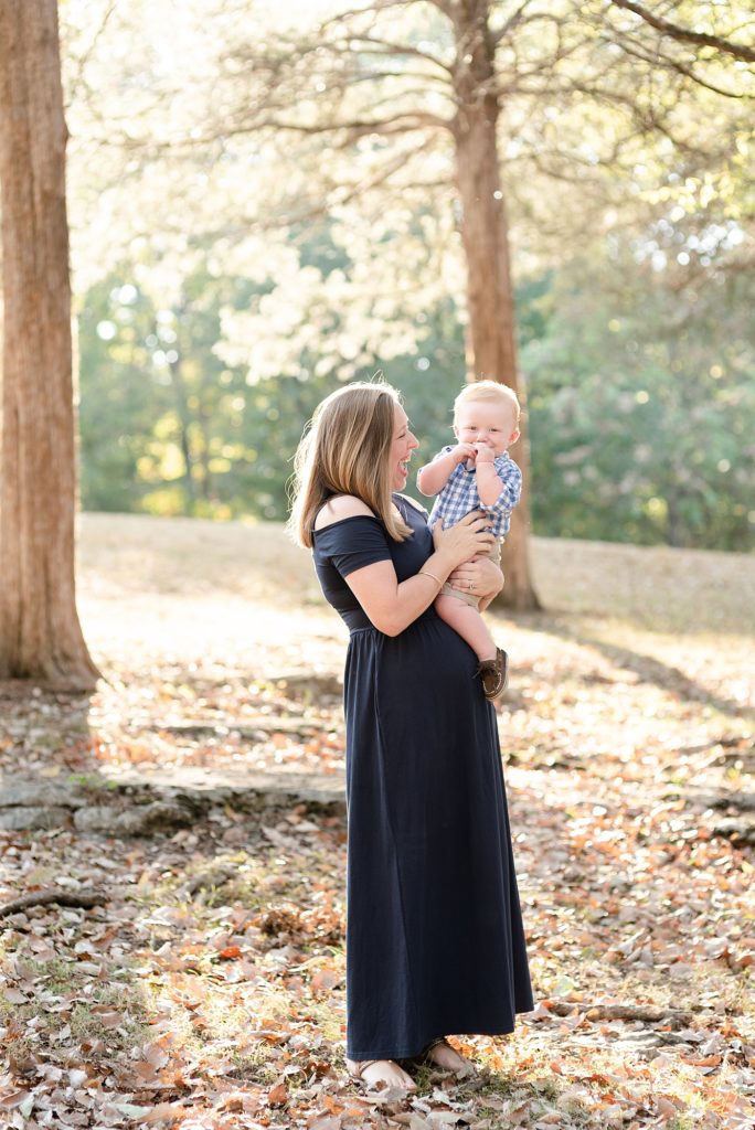 New Mom is holding baby boy in woods for family portraits in Nashville by Dolly DeLong Photography