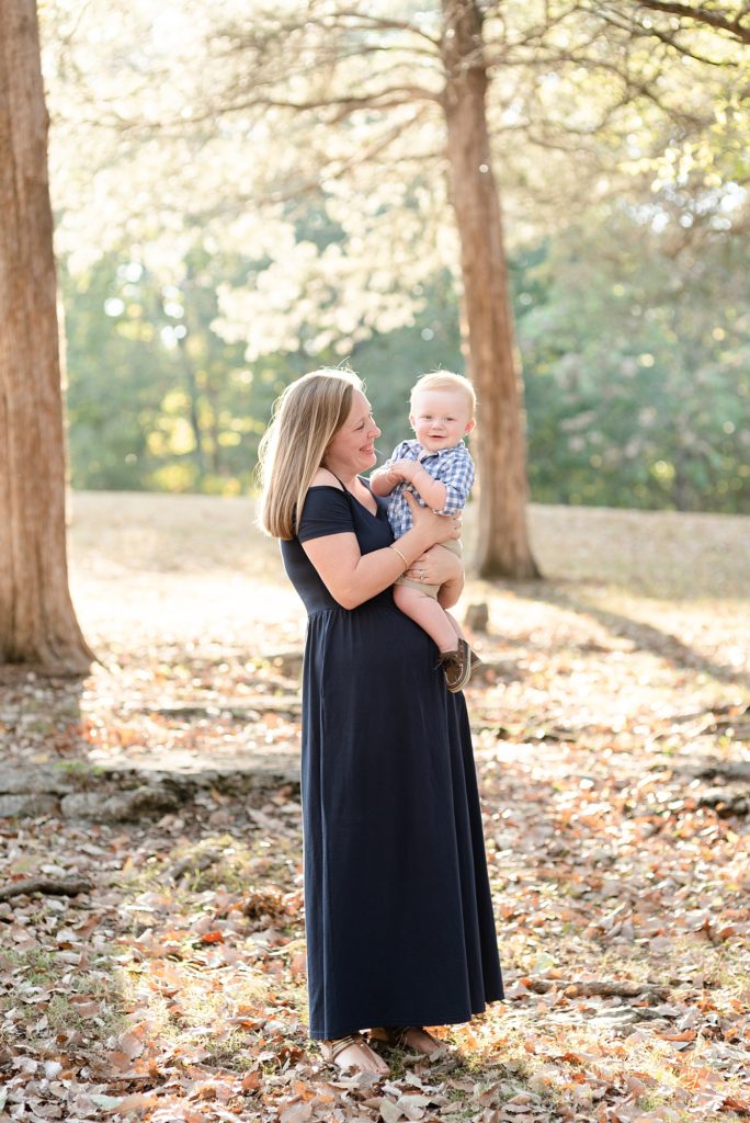 New Mom is holding baby son in woods for family portraits in Nashville by Family Photographer Dolly DeLong Photography