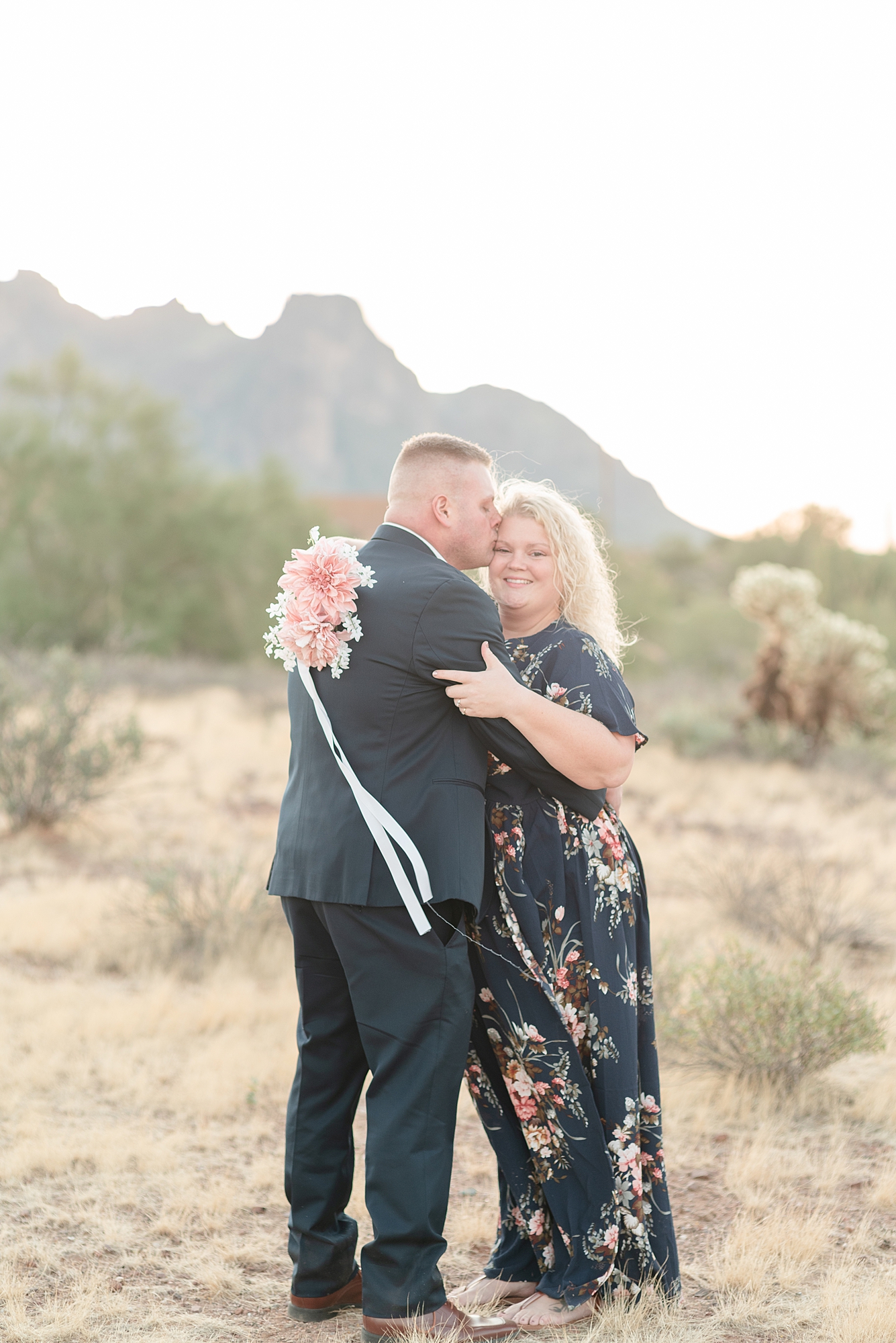 A Man Kisses His fiance on her head for their Arizona Sunrise Engagement Session in Paseo