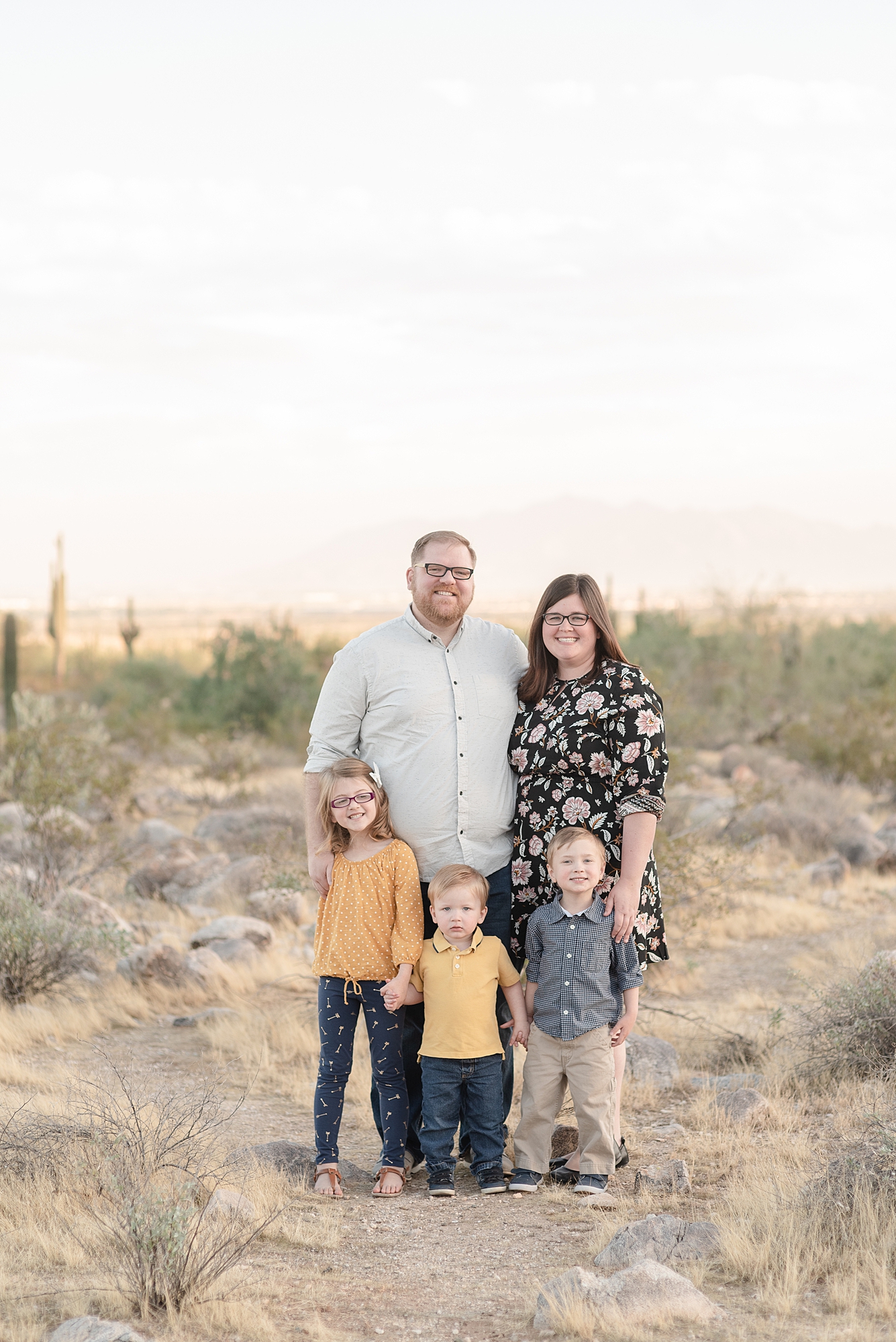 A Family of Five Stands in The Phoenix Arizona Desert for Family Portraits Near the White Tank Mountains in Fall