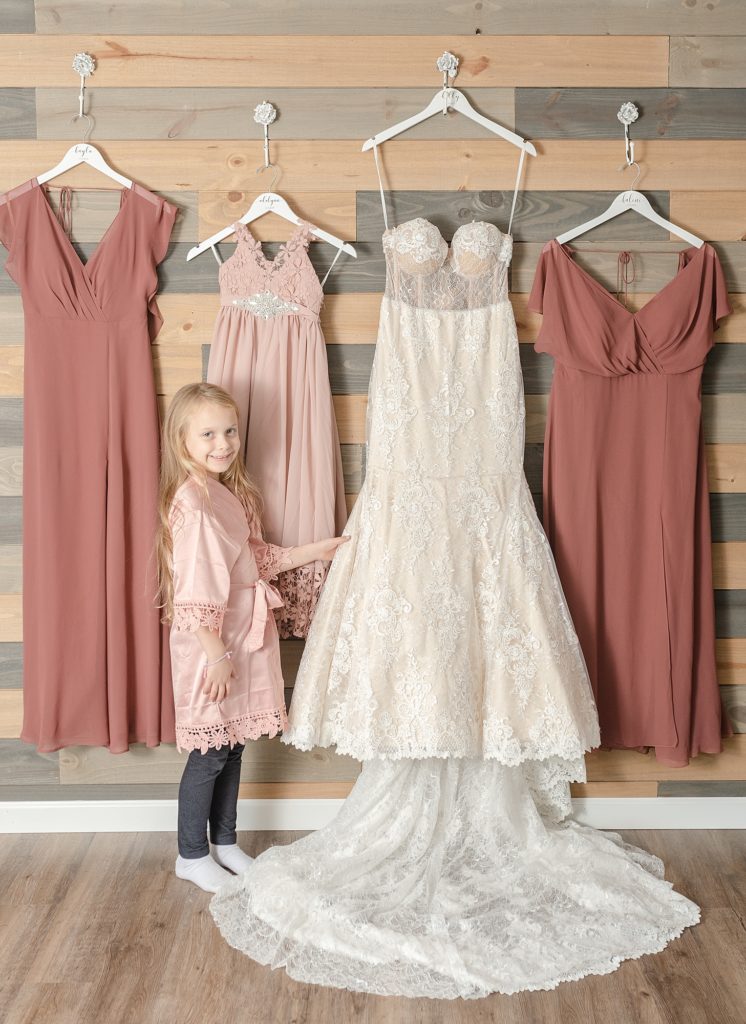 a little girl is standing beside her mother's wedding dress on her mom's wedding day southern wedding in Nashville