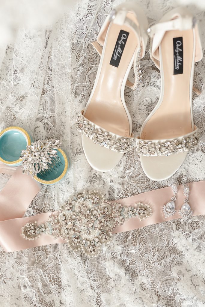wedding day details of shoes hair pieces and a bride's belt with lots of crystals on it