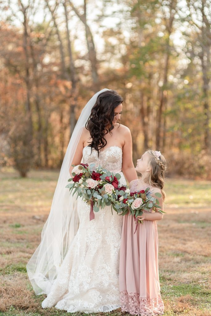 a bride who is a mom is looking down at her daughter who is a bridesmaid and they are smiling for a fall wedding in Nashville