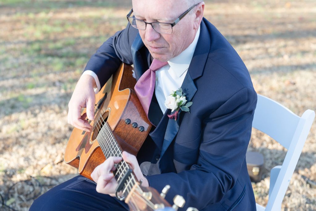 father of the bride playing guitar on wedding day