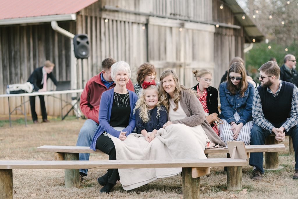 wedding guests bundled up in a blanket at an outdoor southern wedding on a cold day in nashville