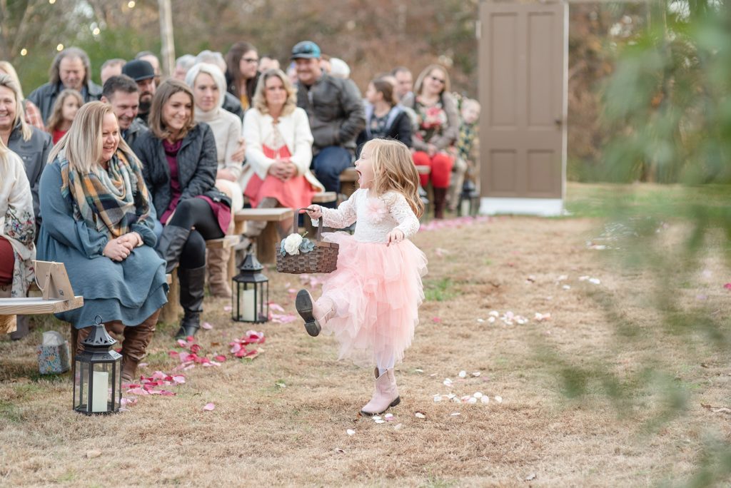 flower girl skipping down the wedding aisle for a fall wedding in the south in Nashville