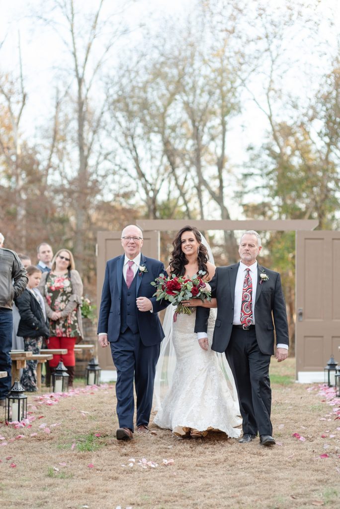 bride is walked down the aisle by two dads