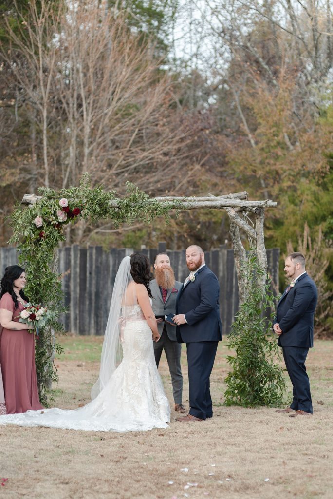 a groom and bride are exchanging wedding vows on their wedding day in the south on a farm in Nashville