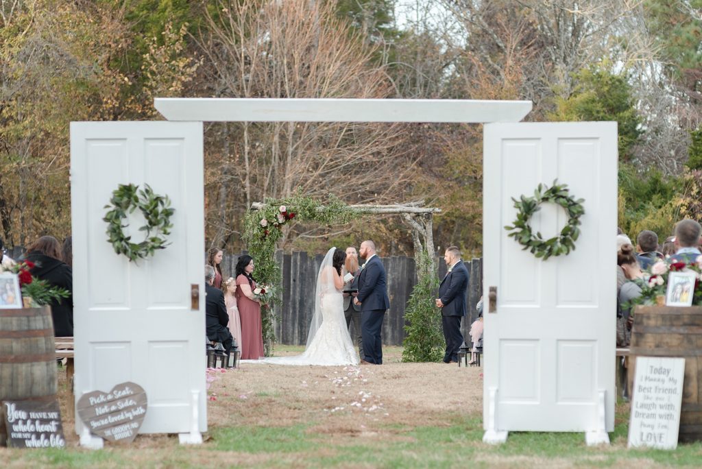 a groom and bride are exchanging wedding vows on their wedding day in the south on a farm in Nashville