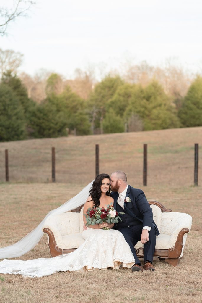 a bride and groom are sitting on a couch for husband and wife portraits for a southern wedding