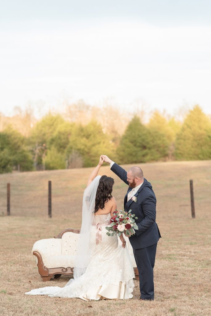 a husband is twirling his new bride for a southern wedding at a farm at hidden creek farm weddings in Nashville