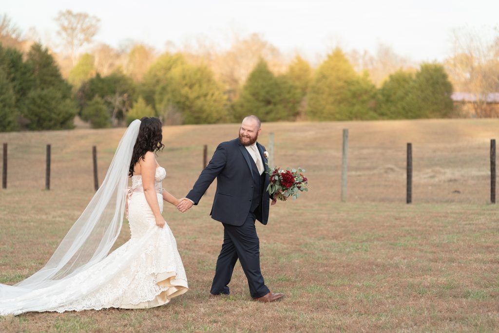 a husband is walking with his wife on a farm at hidden creek farm weddings