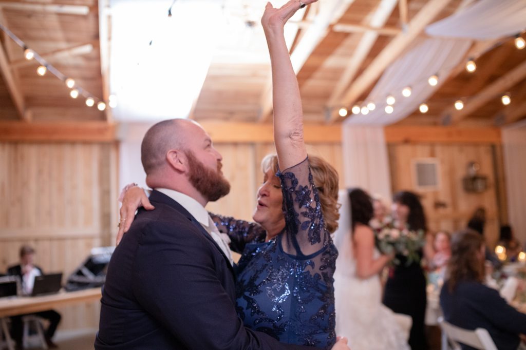 a groom and the mother of the groom are dancing for the mother son dance at his wedding in the south
