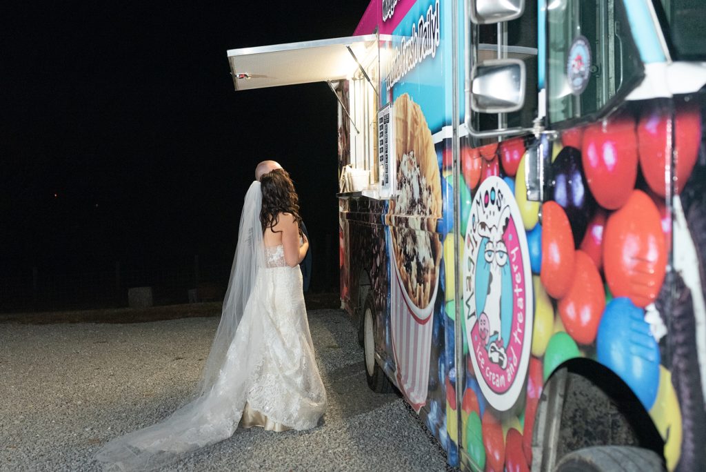 bride and groom are eating at their wedding reception at a wedding ice cream truck featuring maggie moos in Nashville