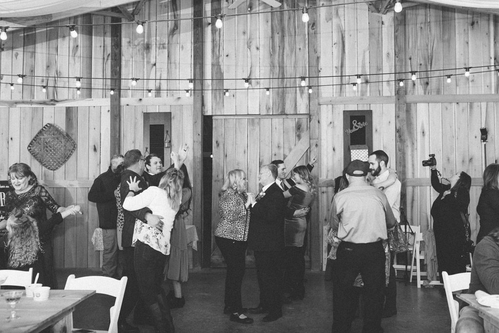 a black and white photo of people dancing at a wedding reception