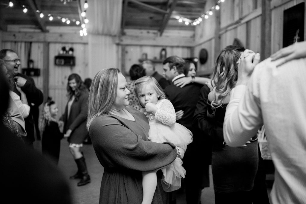 a black and white portrait of a woman and her baby dancing at a wedding reception
