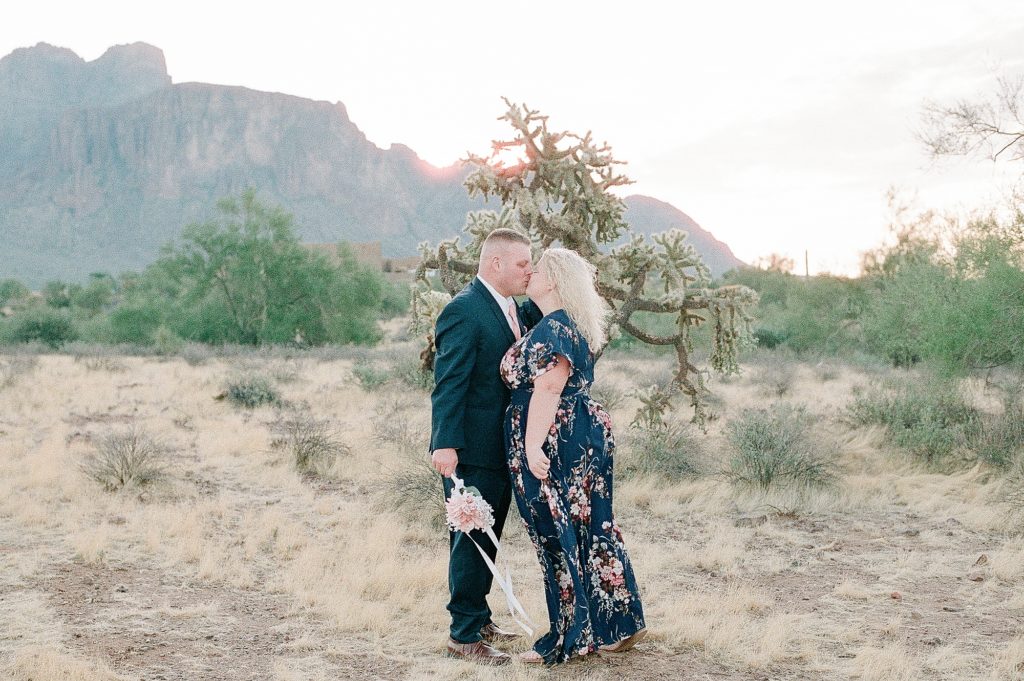 a man and woman are standing in the desert near the paseo in phoenix arizona for their engagement session and picture is a film photo by Dolly DeLong Photography