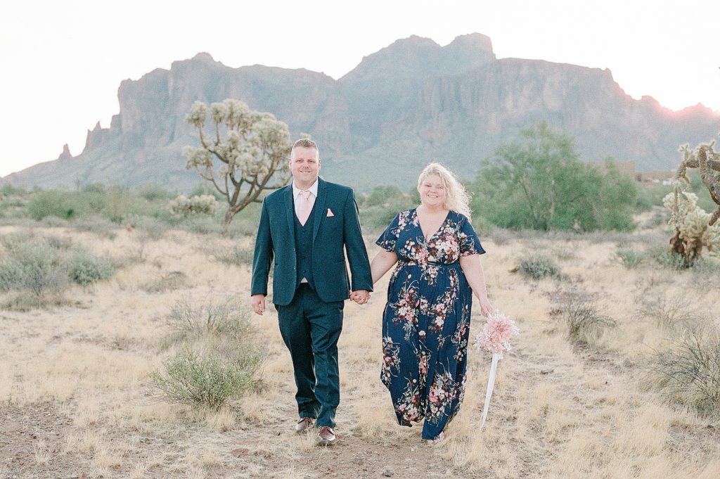 a man and woman are standing in the desert near the paseo in phoenix arizona for their engagement session and picture is a film photo by Dolly DeLong Photography