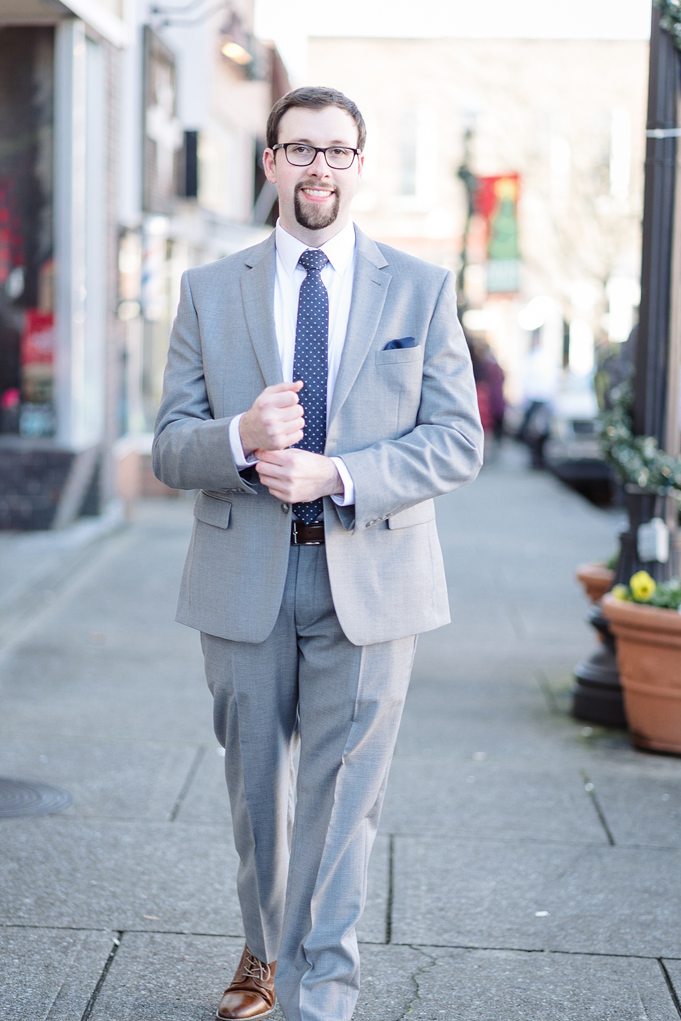 A groom is smiling at the camera before his winter wedding in downtown murfreesboro by Dolly DeLong Photography