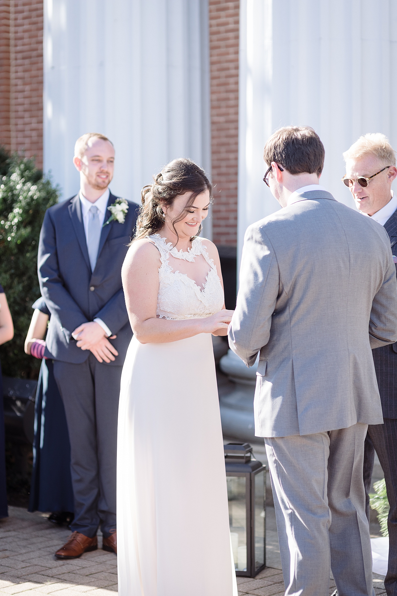 A wife is accepting a ring from her husband as they exchange vows on their winter wedding in Murfreesboro Tennessee by Dolly DeLong Photography