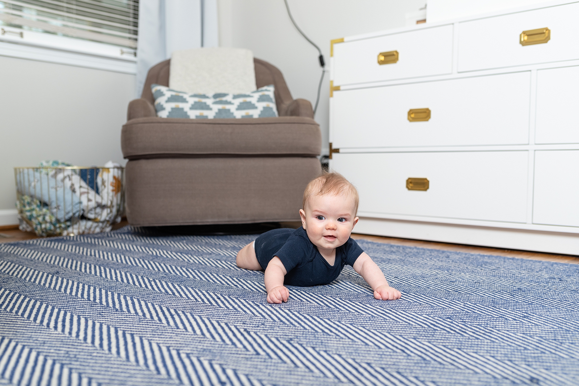 a 6 month old boy on a rug in his room for milestone photos