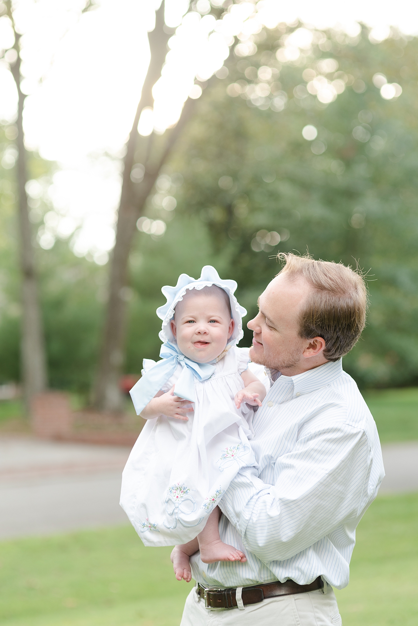 proud dad holding his youngest daughter for a southern family photo session by Dolly DeLong