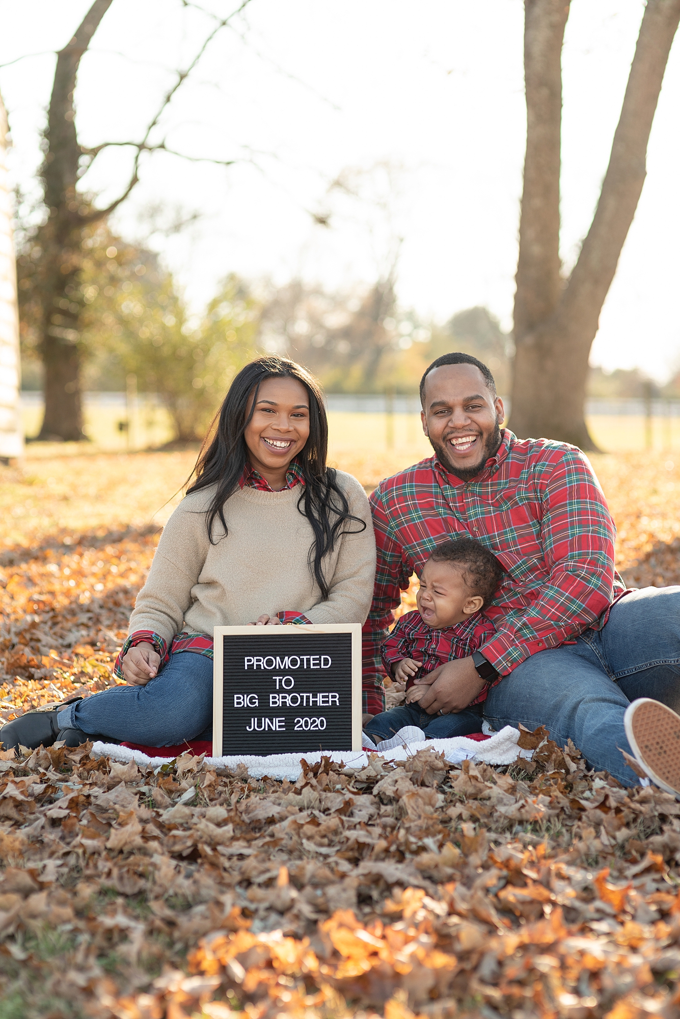 announcement picture of a family of three announcing new baby coming soon