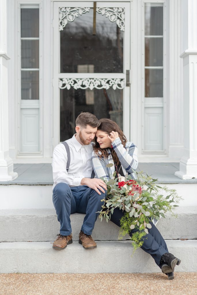 wife and husband sitting on front porch steps snuggling together at Promise Manor in Lynchburg, TN by Dolly DeLong Photography