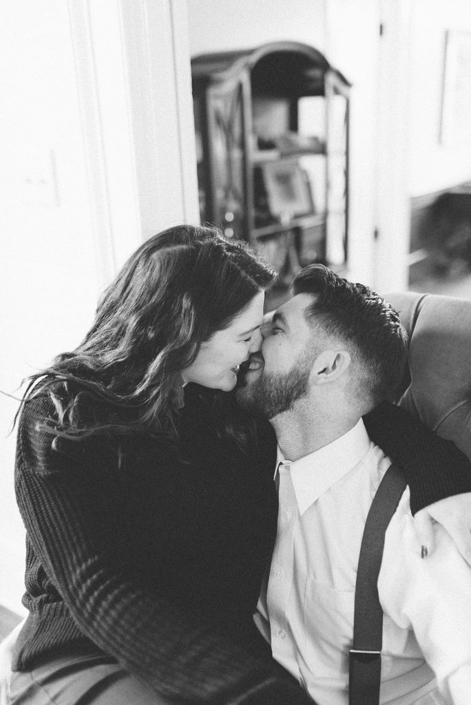 black and white photo of a husband and a wife giggling as they go in for a kiss