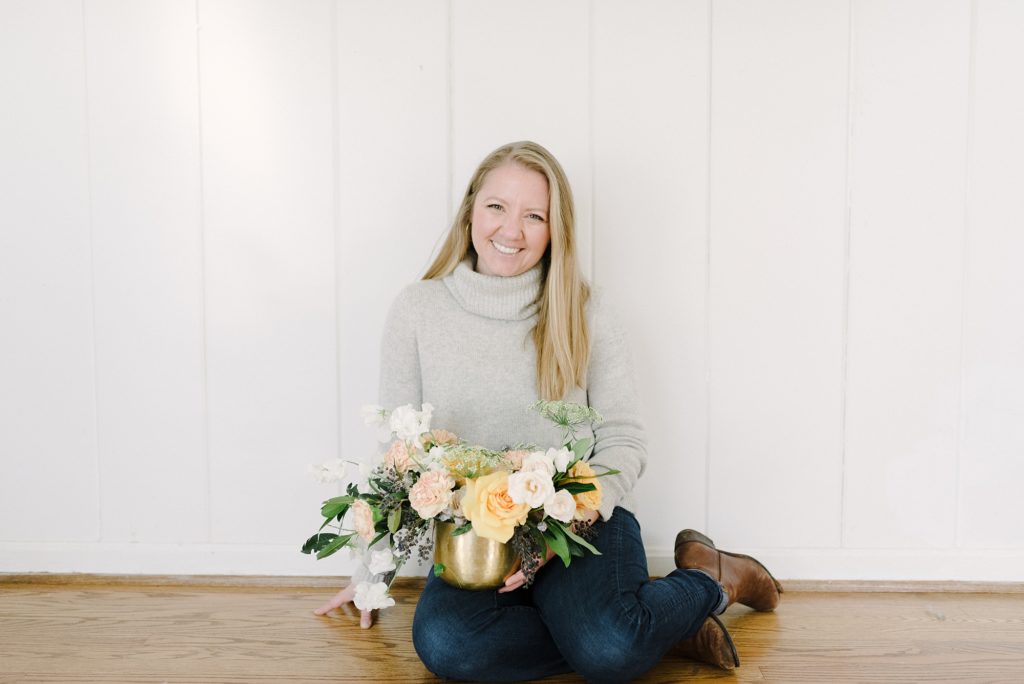 woman smiling at camera while holding a bouquet of flowers