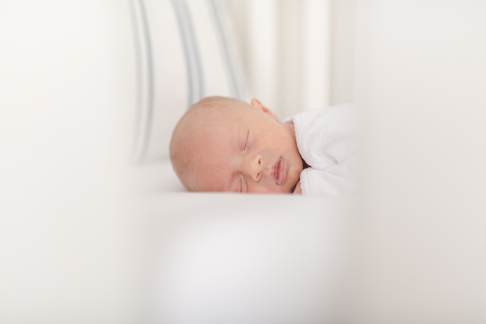 newborn baby girl sleeping in her crib facing the camera in Nashville by Nashville Family Photographers Dolly DeLong Photography
