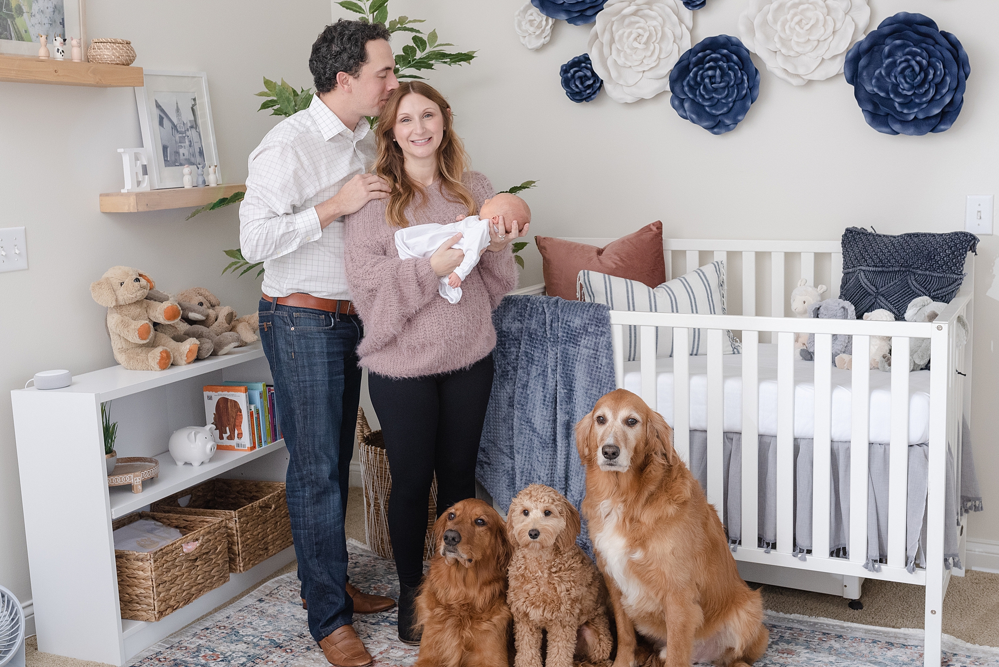 newborn family photography session in Nashville Tennessee featuring three family dogs who are wanting to be in the family photo in the newborn nursery