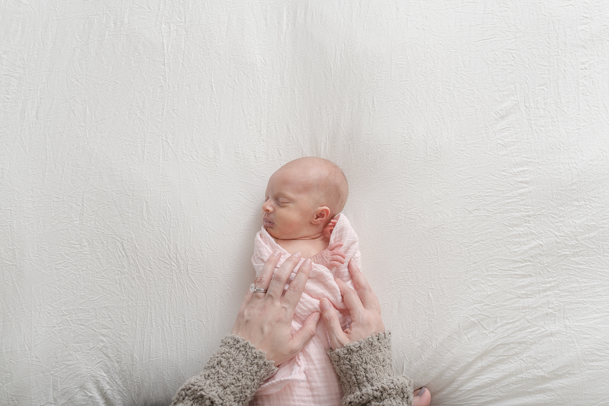 portrait of a newborn baby girl with her mom's hands over her chest by Dolly DeLong Photography Nashville family Photographer