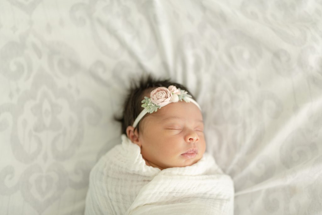sleeping baby girl in a white swaddle for lifestyle family and newborn photos by nashville family and lifestyle photographer Dolly DeLong Photography