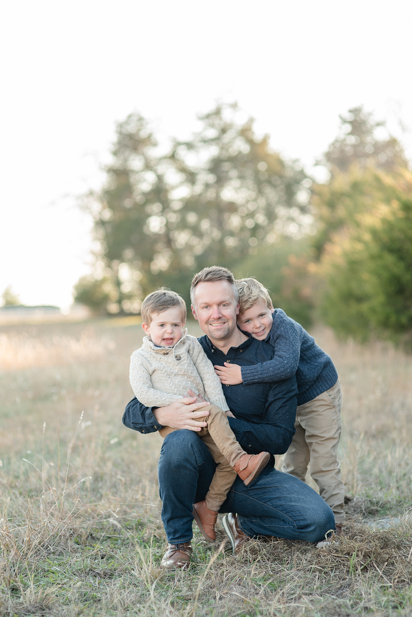 a father and his two boys are taking their picture with Nashville family photographer Dolly DeLong Photography