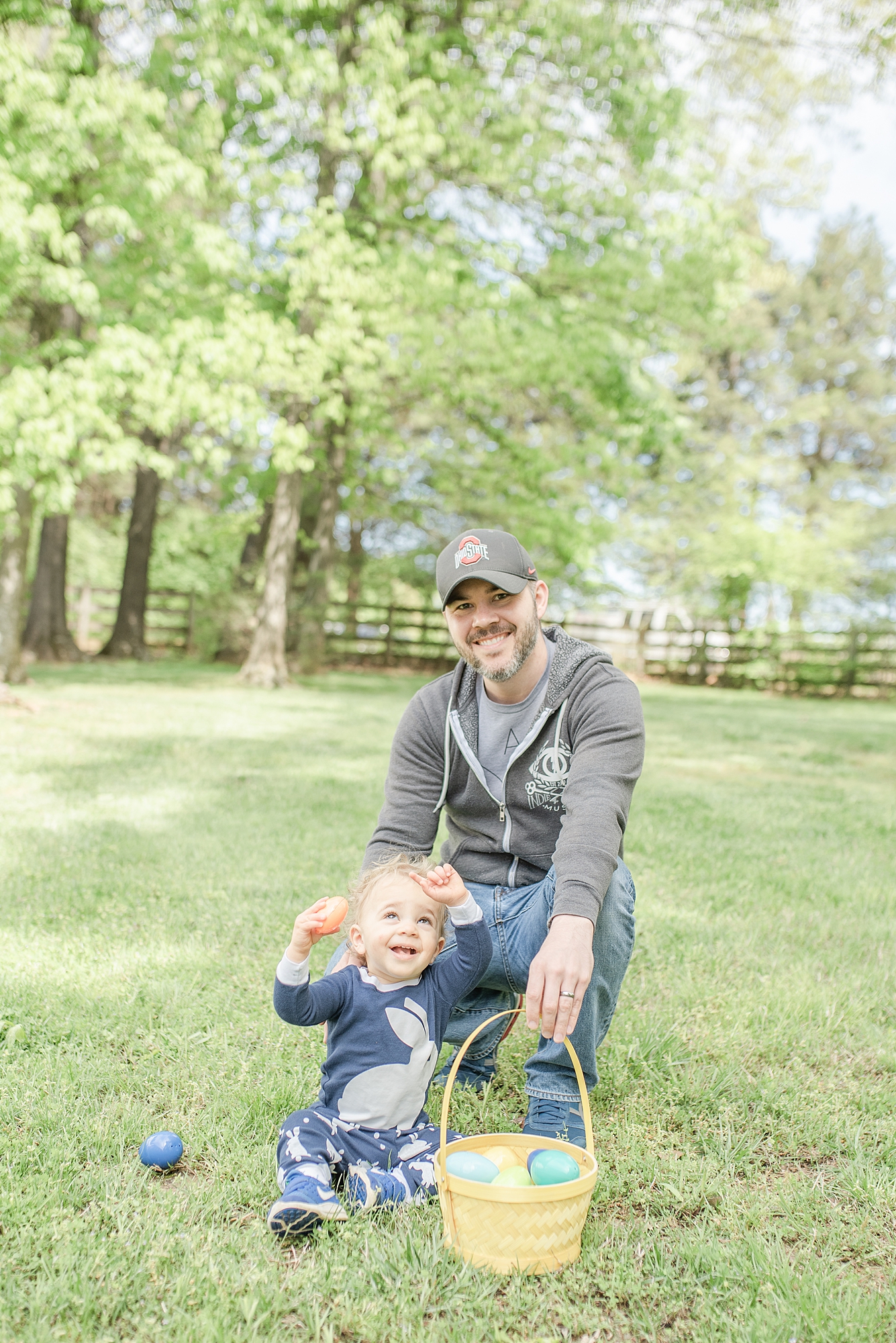 image of a little toddler hunting for easter eggs with his father in Nashville, TN by Nashville Family Photographer Dolly DeLong Photography