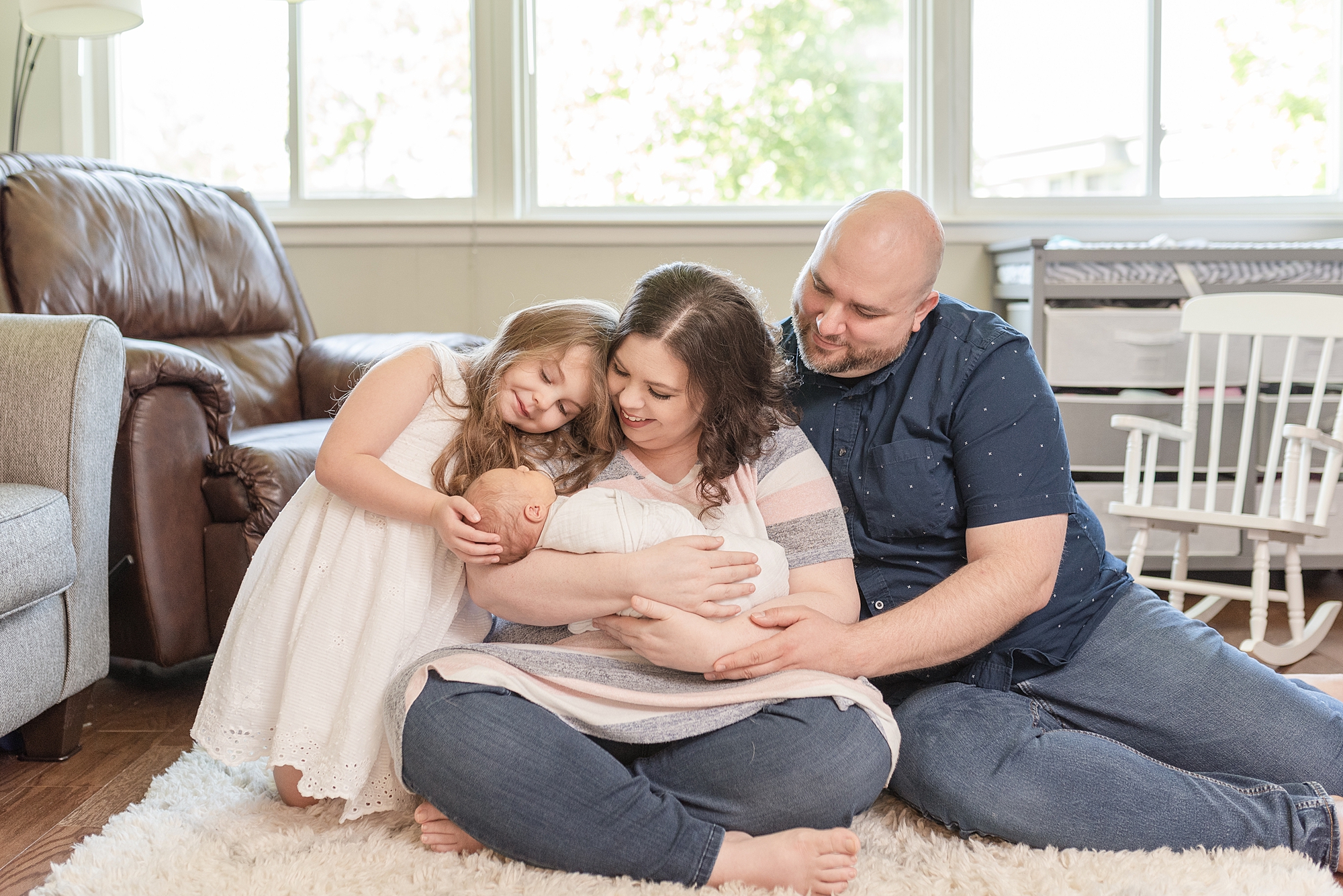 a family of four looking down at newborn baby brother for family photos in green hills Tennessee by nashville family photographer dolly delong photography