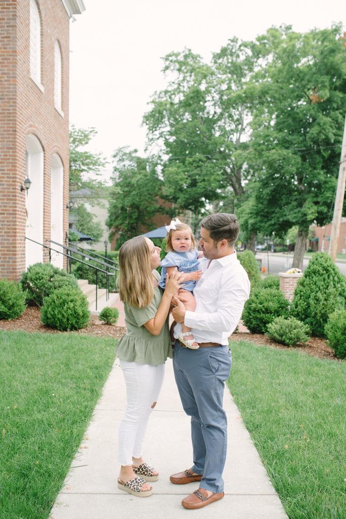 family of three smiling and laughing together in downtown franklin tennessee by nashville family photographer Dolly DeLong Photography