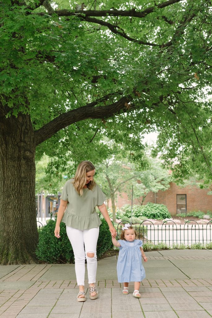 mom and toddler daughter walking towards the camera for family photos in downtown Franklin Tennessee by Nashville Family Photographer Dolly DeLong Photography
