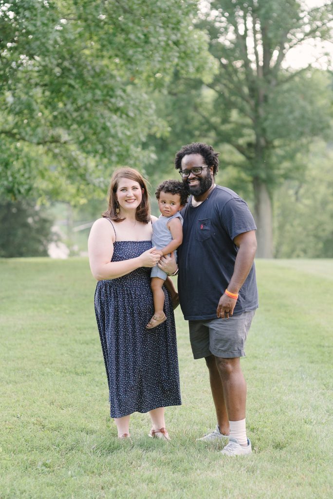 family of three standing at the Nashville Agricultural Center for son's 1st birthday milestone photos by Nashville family photographer Dolly DeLong Photography