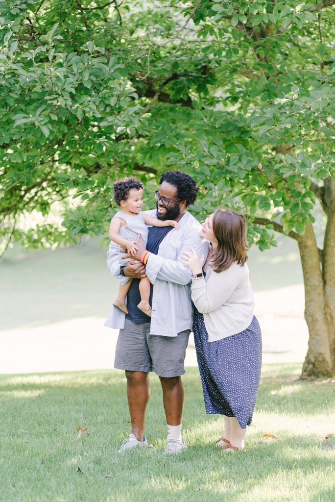 a family of three standing at the nashville agricultural center for family photos by Nashville family photographer Dolly DeLong Photography
